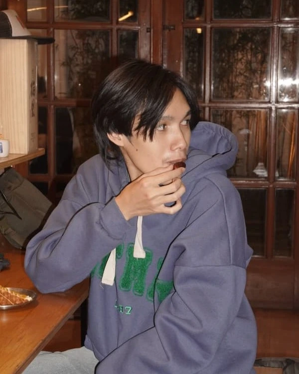 Dimas sitting at a Japanese restaurant while looking away from the camera.